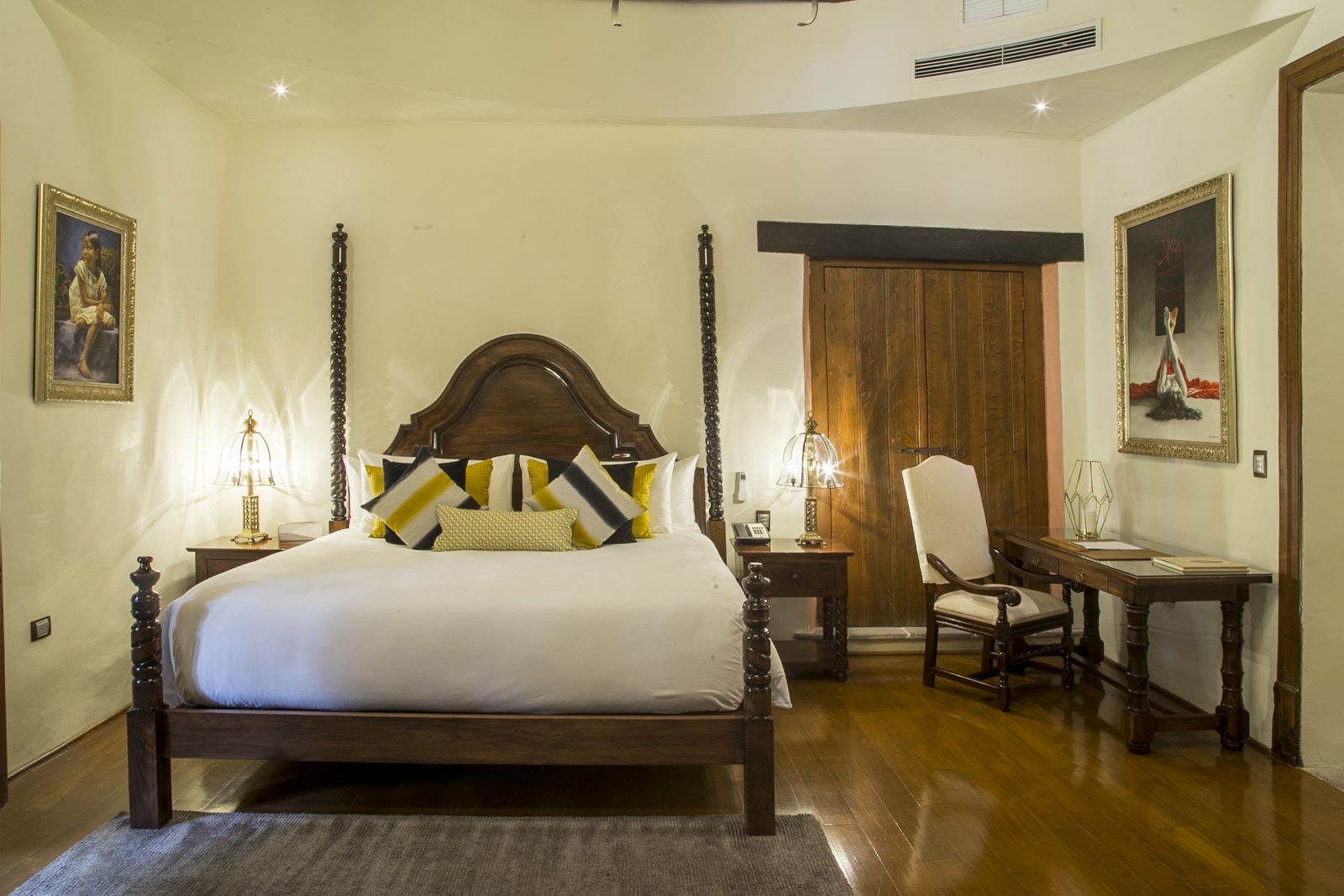 Suite Talavera vista de frente: cama king de cuatro postes y pinturas en los muros.